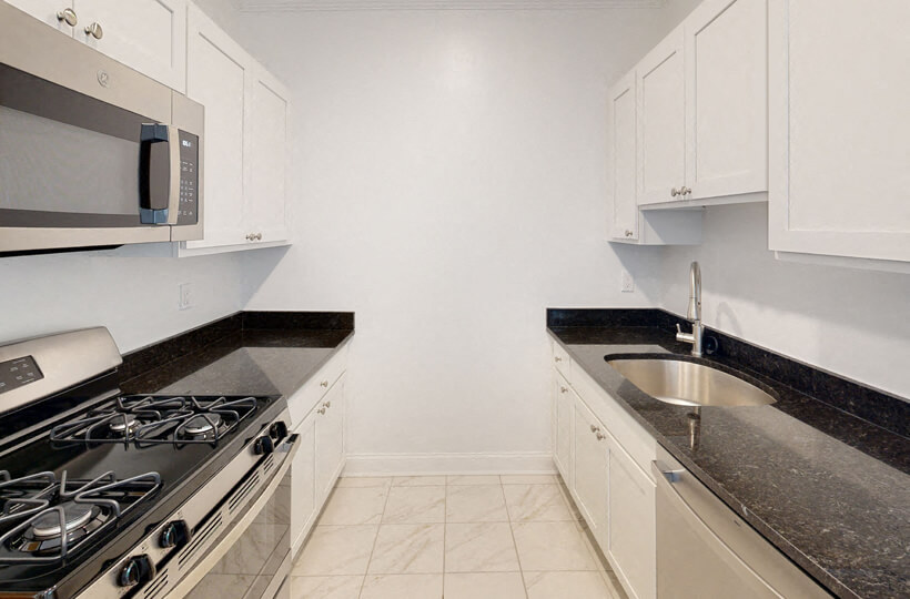 a kitchen with white cabinets and a stove and a sink